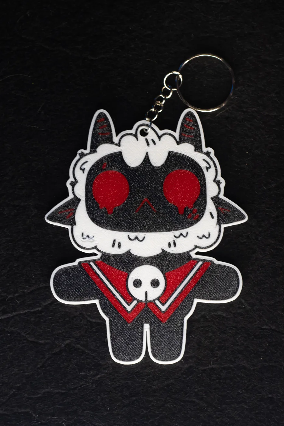 3D-printed Cult of the Lamb keychain: the Lamb with red eyes and a skull collar, on a metal key ring