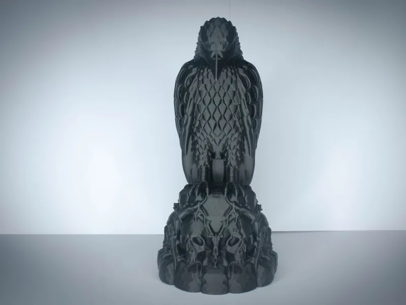 Black 3D-printed gothic raven figurine perched on a base of carved skulls