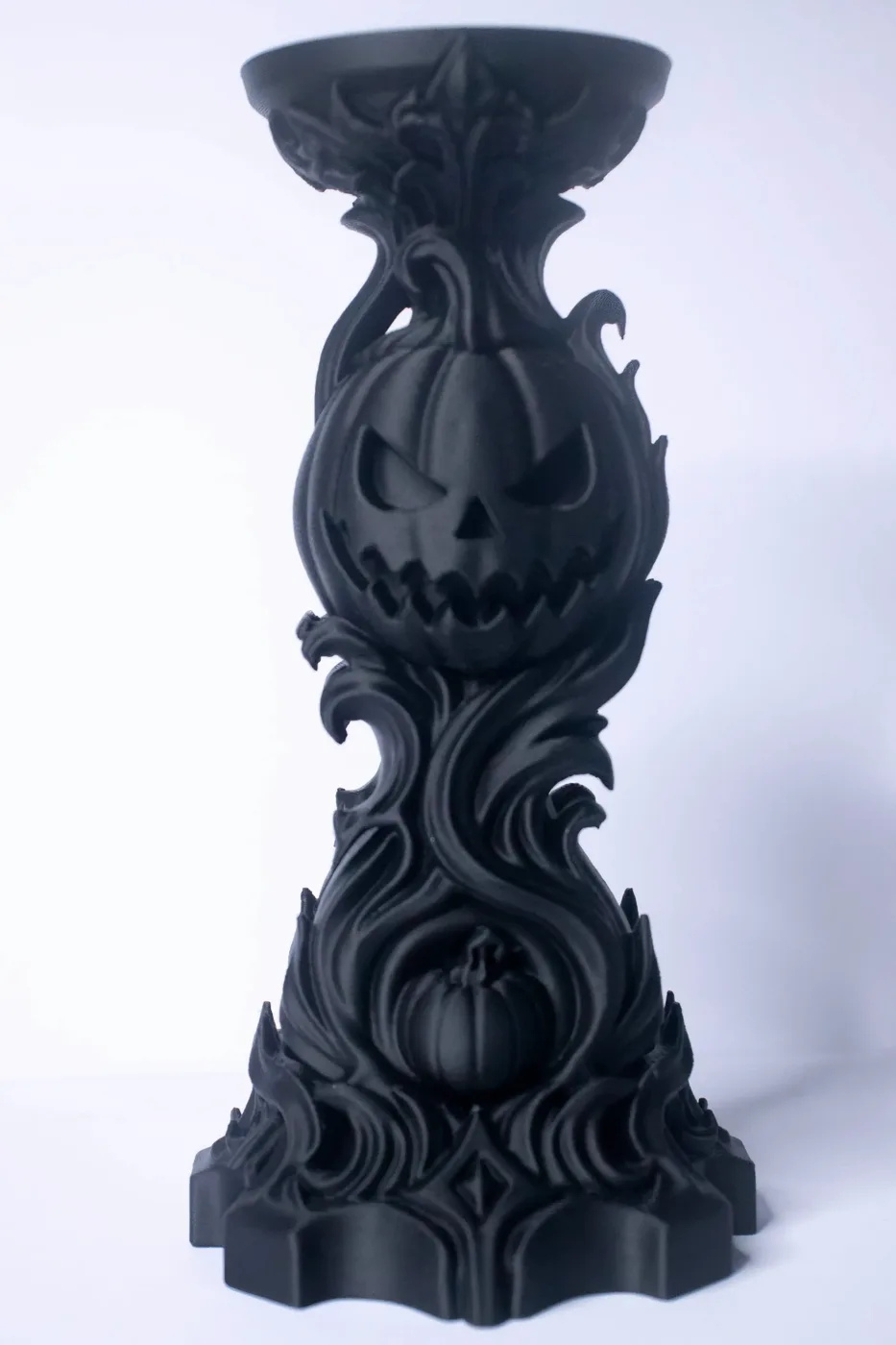 Black 3D-printed Samhain candle holder with a carved jack-o'-lantern and swirling gothic ornament